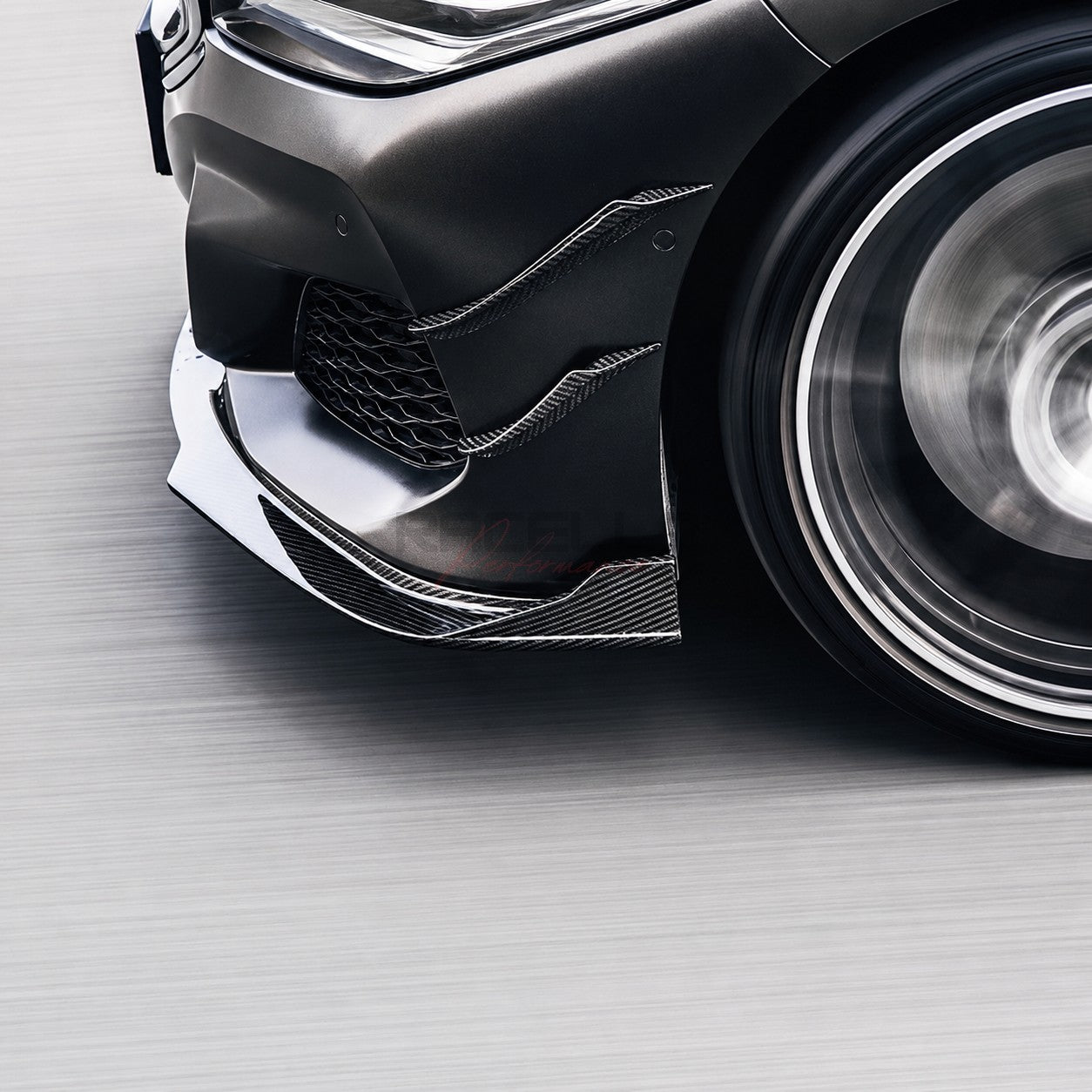 Echtcarbon Front Canards an der Frontstoßstange eines dunklen BMW montiert, Detailansicht von unten in Fahrbewegung