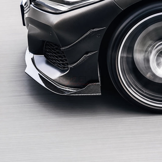 Echtcarbon Front Canards an der Frontstoßstange eines dunklen BMW montiert, Detailansicht von unten in Fahrbewegung