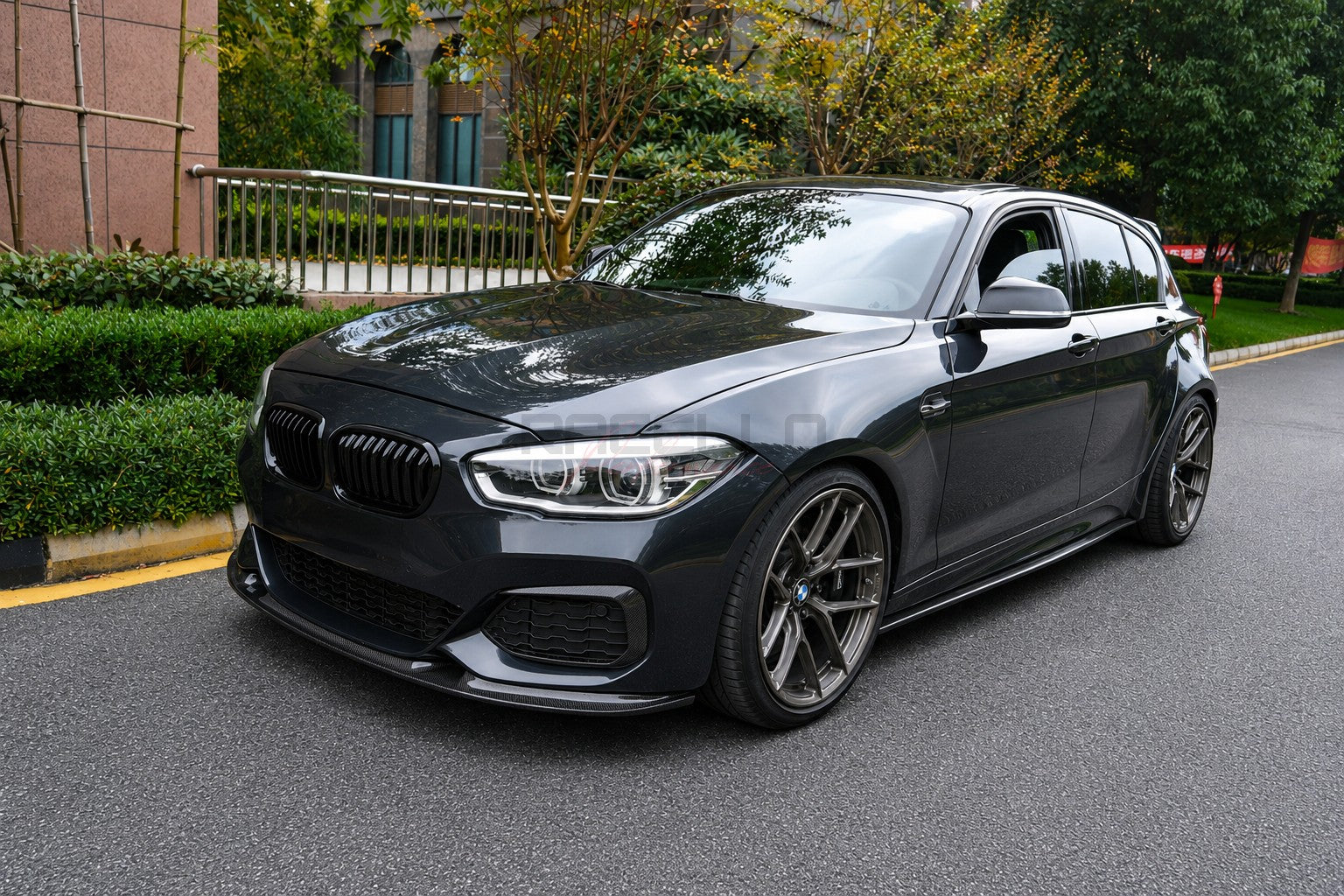 Dunkelgrauer BMW 1er F20 LCI mit montiertem L1X1 Echtcarbon Frontspoiler und Carbon Seitenschwellern in einer Außenaufnahme