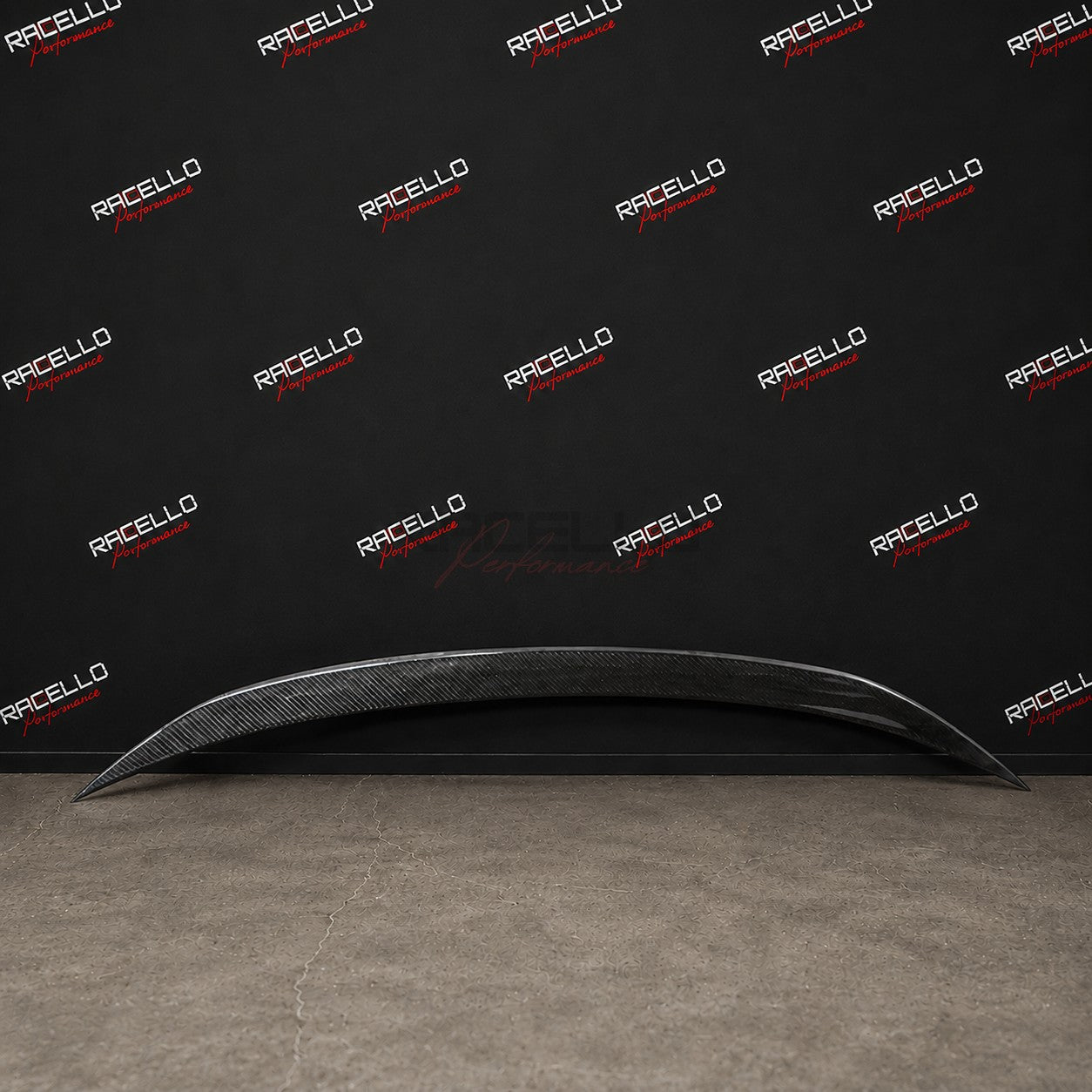 S3X2 Echtcarbon Heckspoiler fuer BMW 3er G20 G21 vor der Racello Markenwand